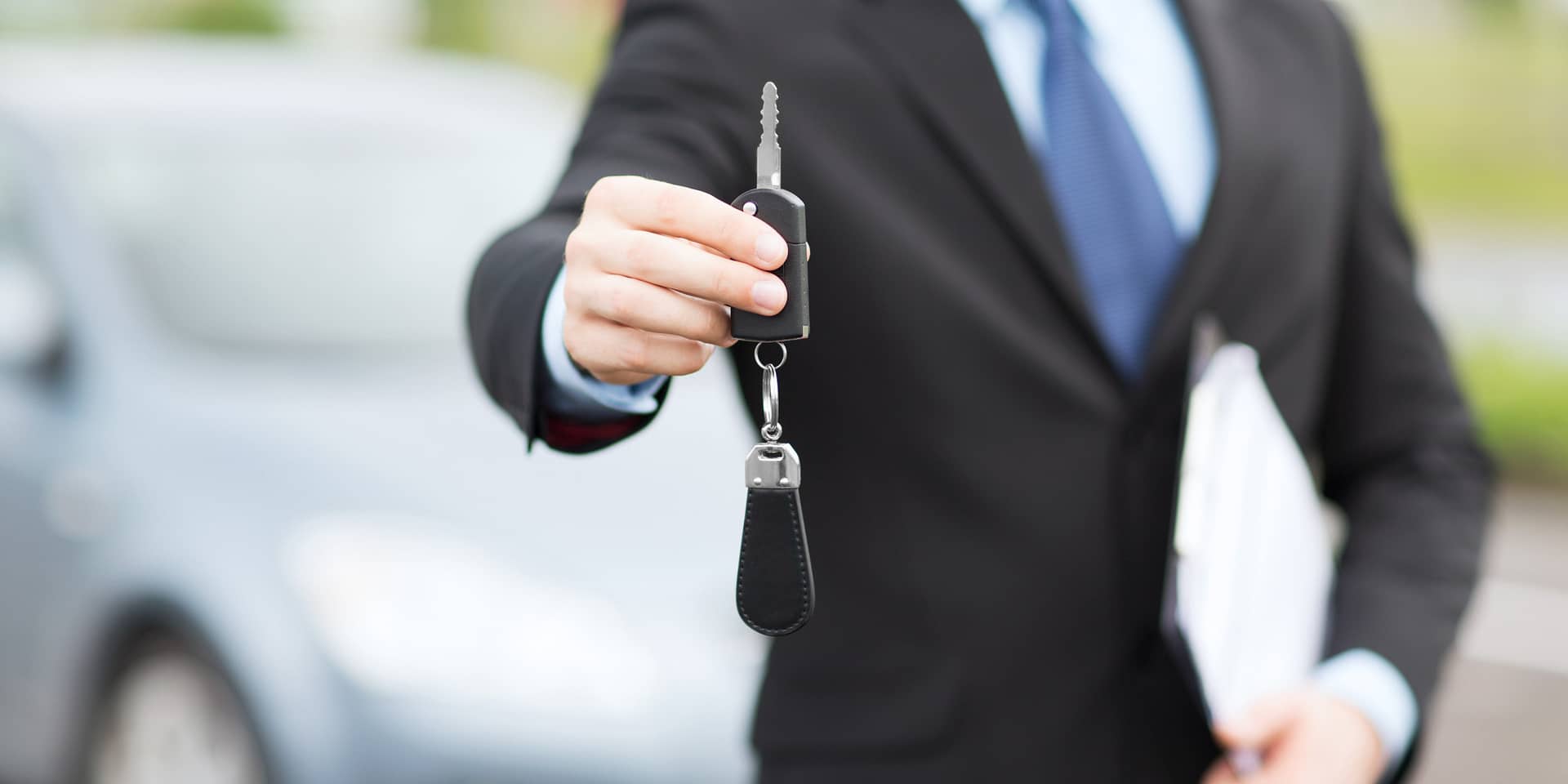 guy in suit holding car keys