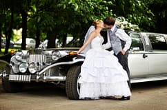 wedding couple kissing outside of a vintage car