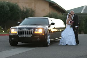 wedding couple and a black limo